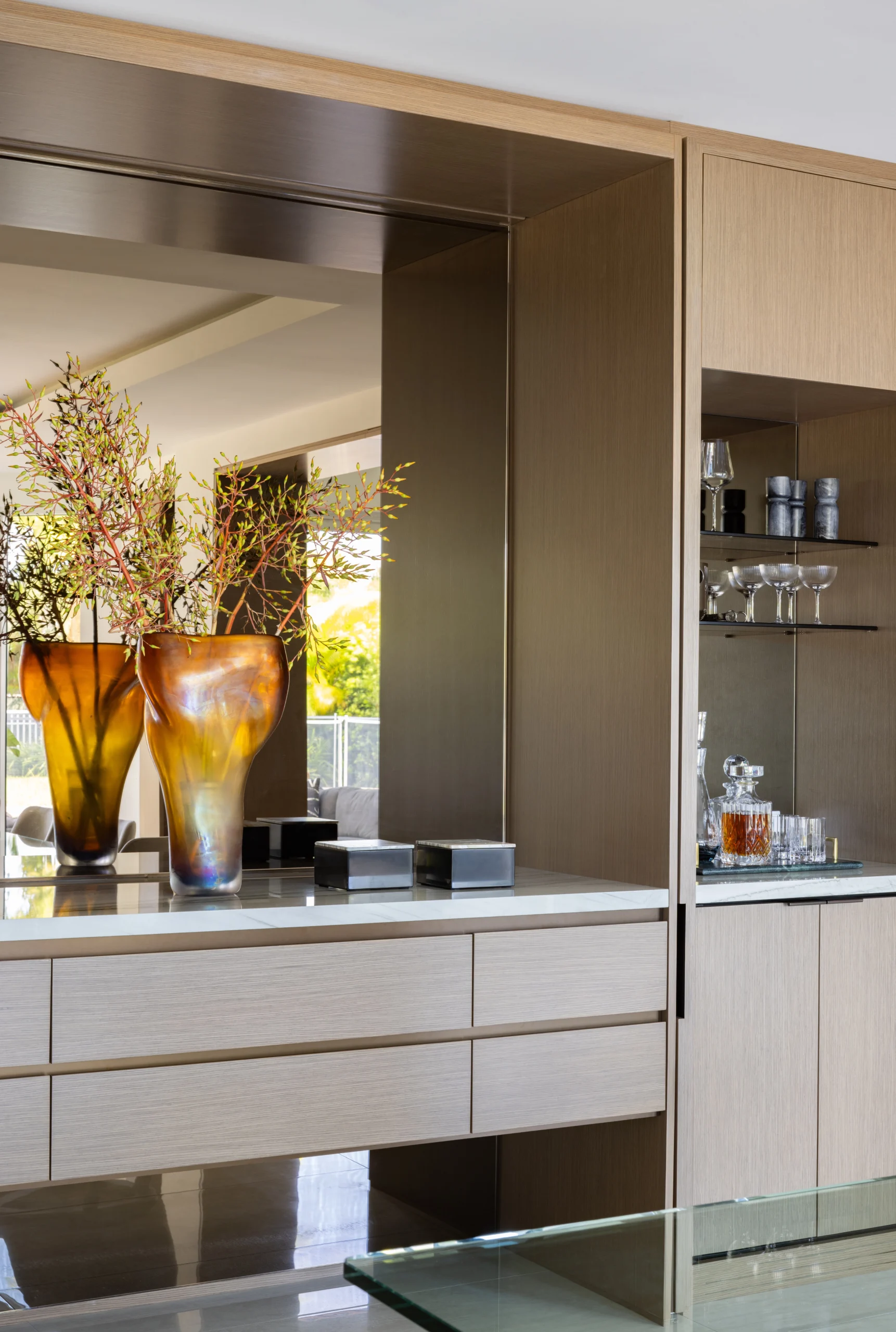 Custom oak millwork with mirrored niche, floating drawers and integrated glassware display