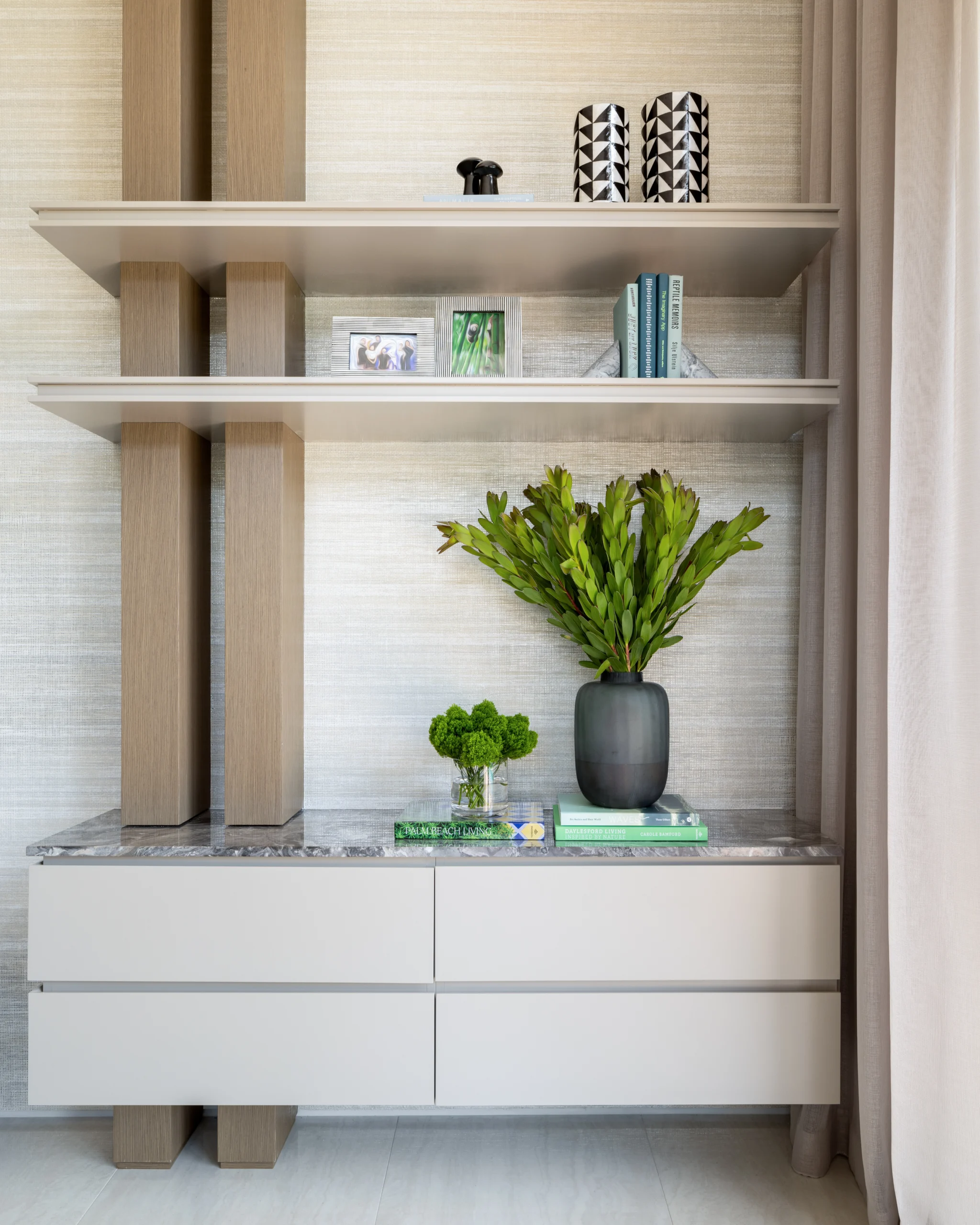 Custom shelving detail with floating drawers, stone top and layered decorative styling