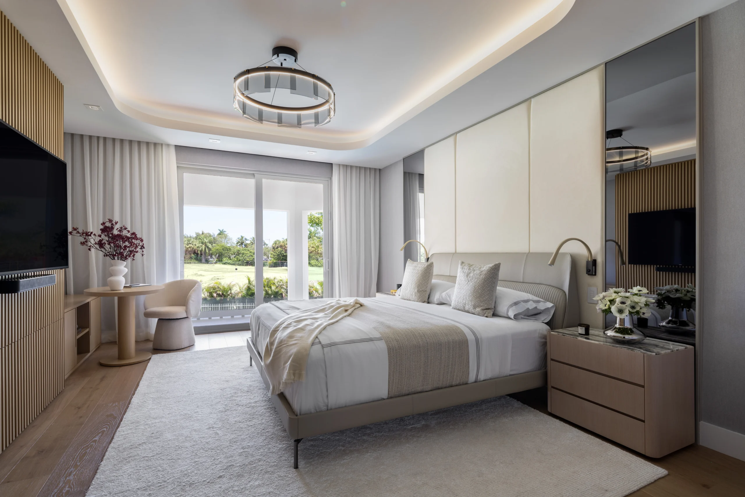 ESerene primary bedroom with upholstered wall panels, curved ceiling detail and garden views