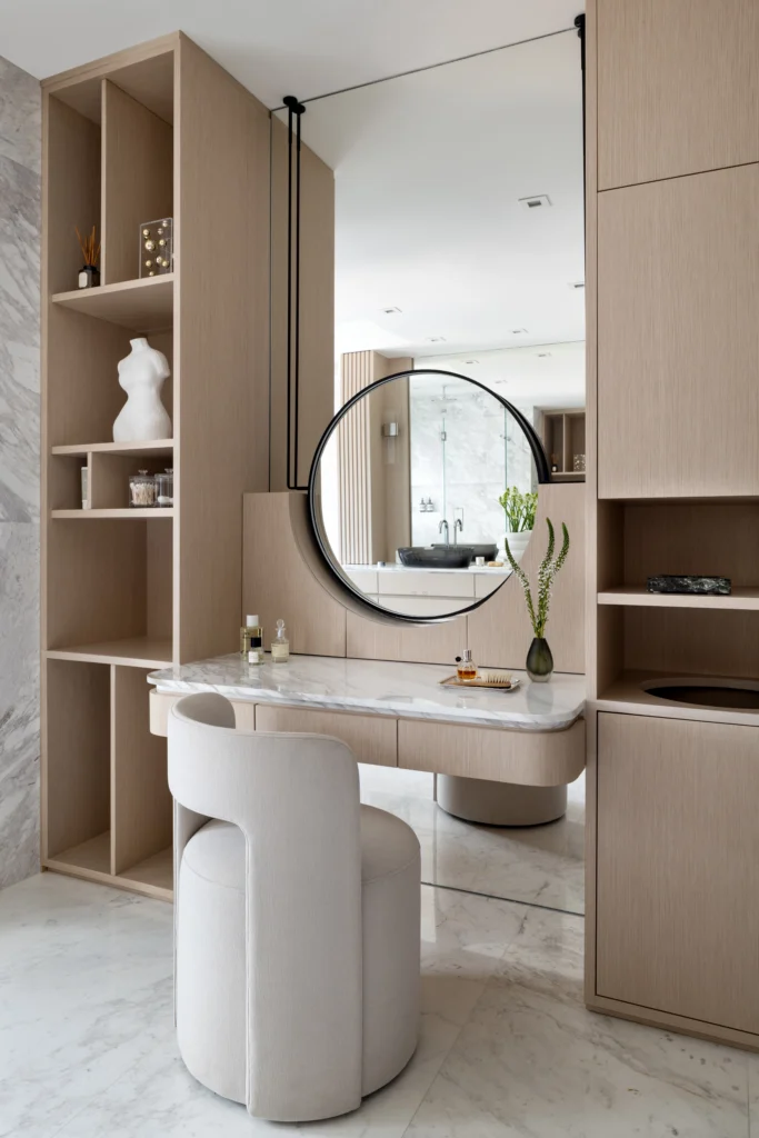 Custom vanity with marble countertop, round mirror and oak cabinetry in a sophisticated residence