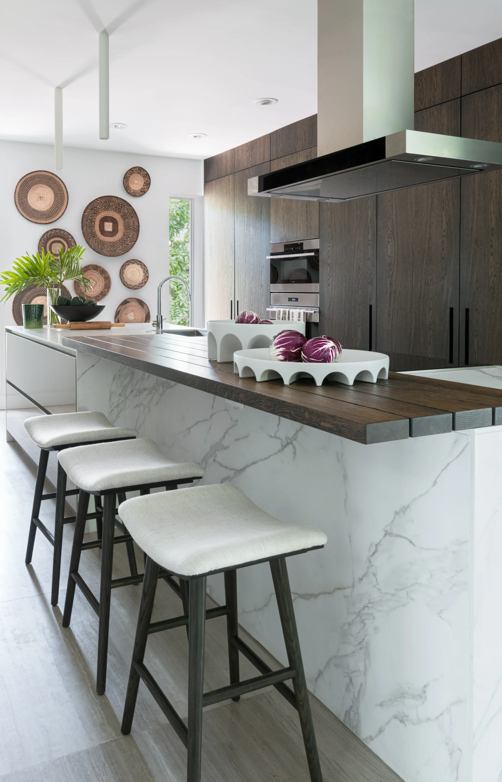 Open-plan luxury kitchen with marble island, dark oak cabinetry and custom bar seating