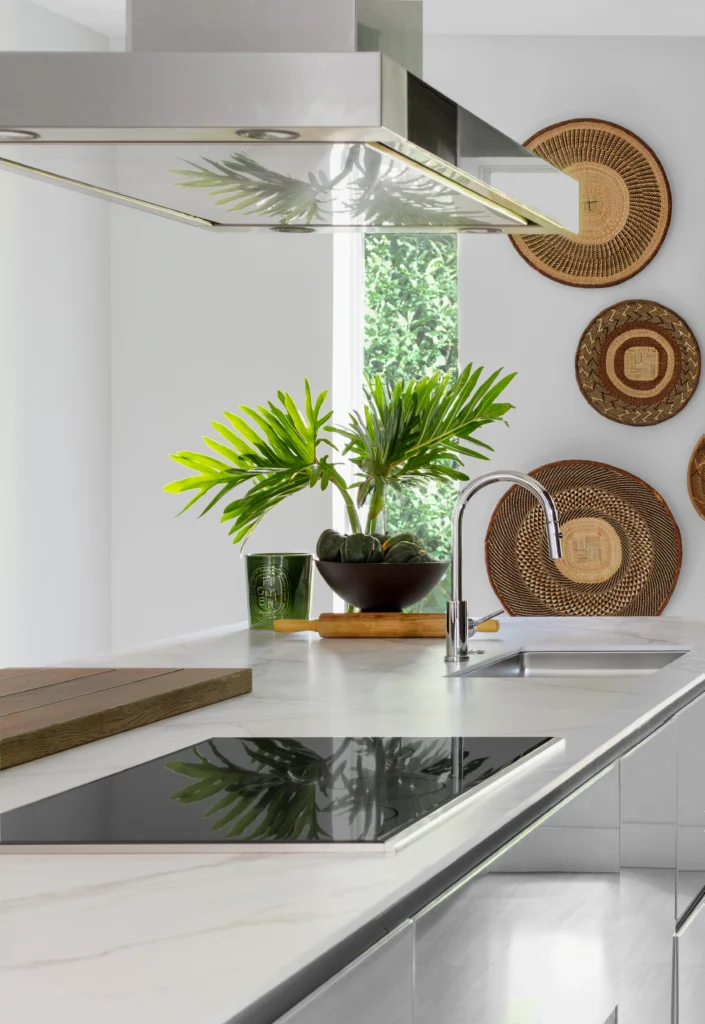 Minimalist luxury kitchen with marble island, integrated cooktop and tropical styling